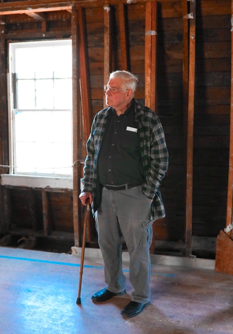 Terry Meyers stands inside the 18th-century Bray School building look off the viewer's left.