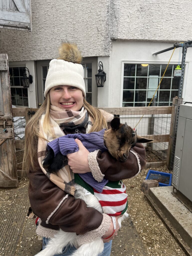 An image of Katherine holding a baby goat.