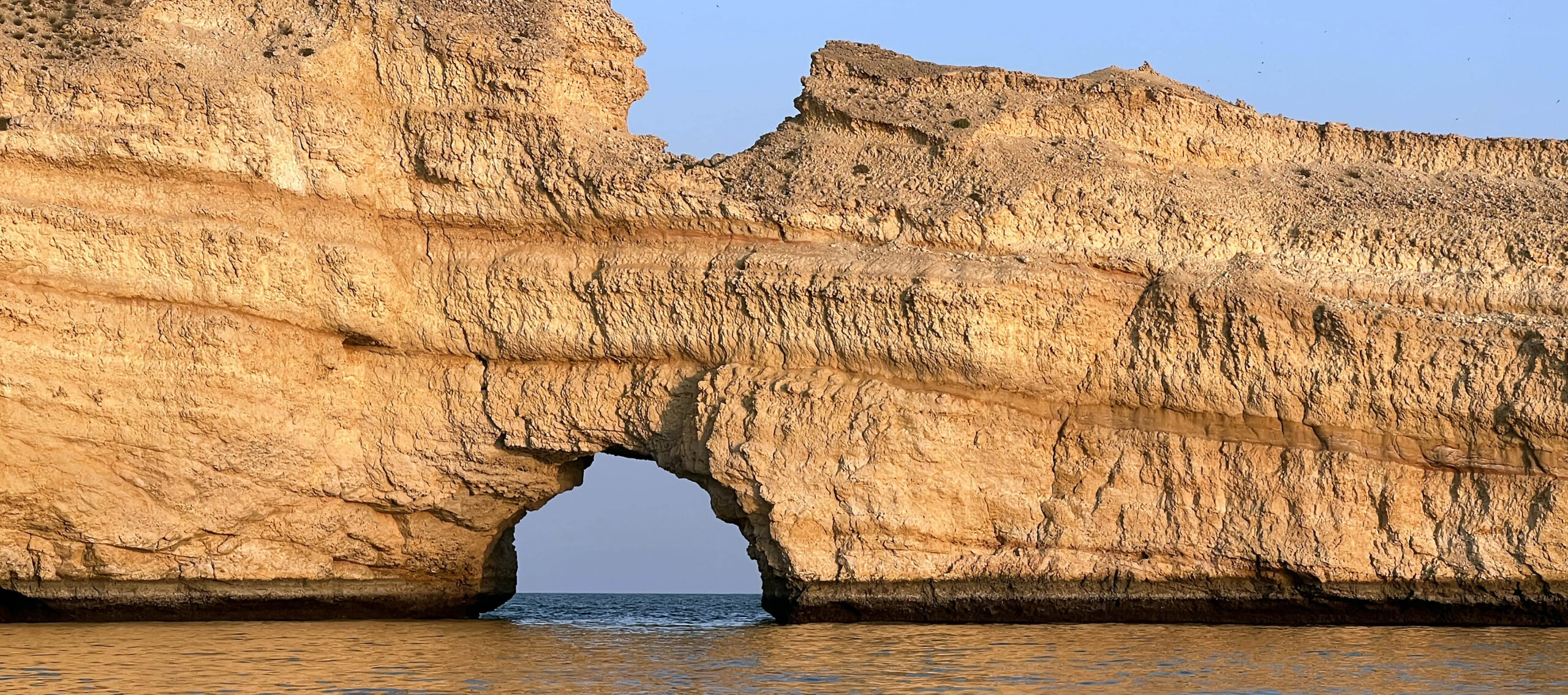 a sea arch cut from sedimentary rocks off Oman's coast